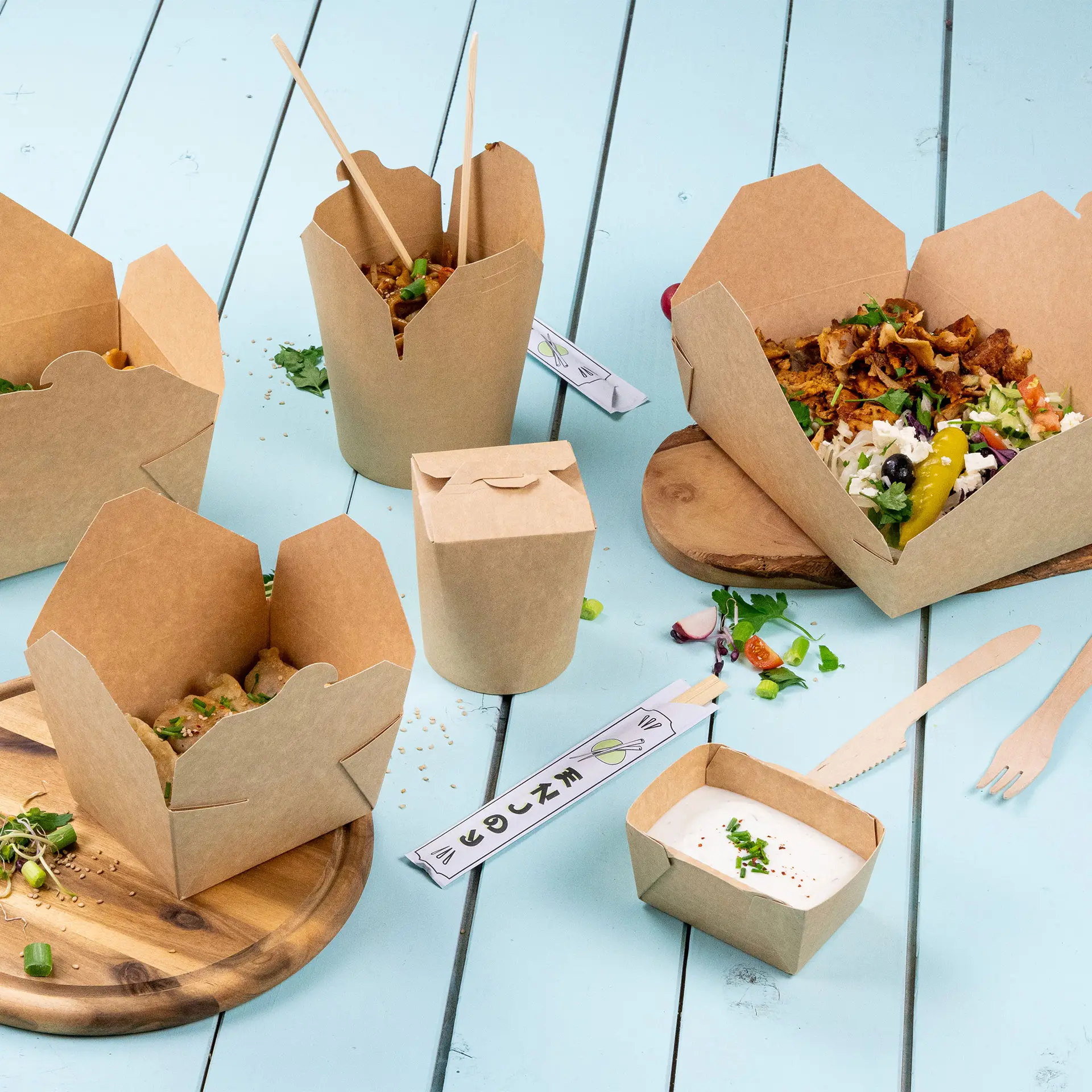 Takeaway food containers in brown cardboard, ideal for hot and cold dishes, arranged on a blue wooden surface.
