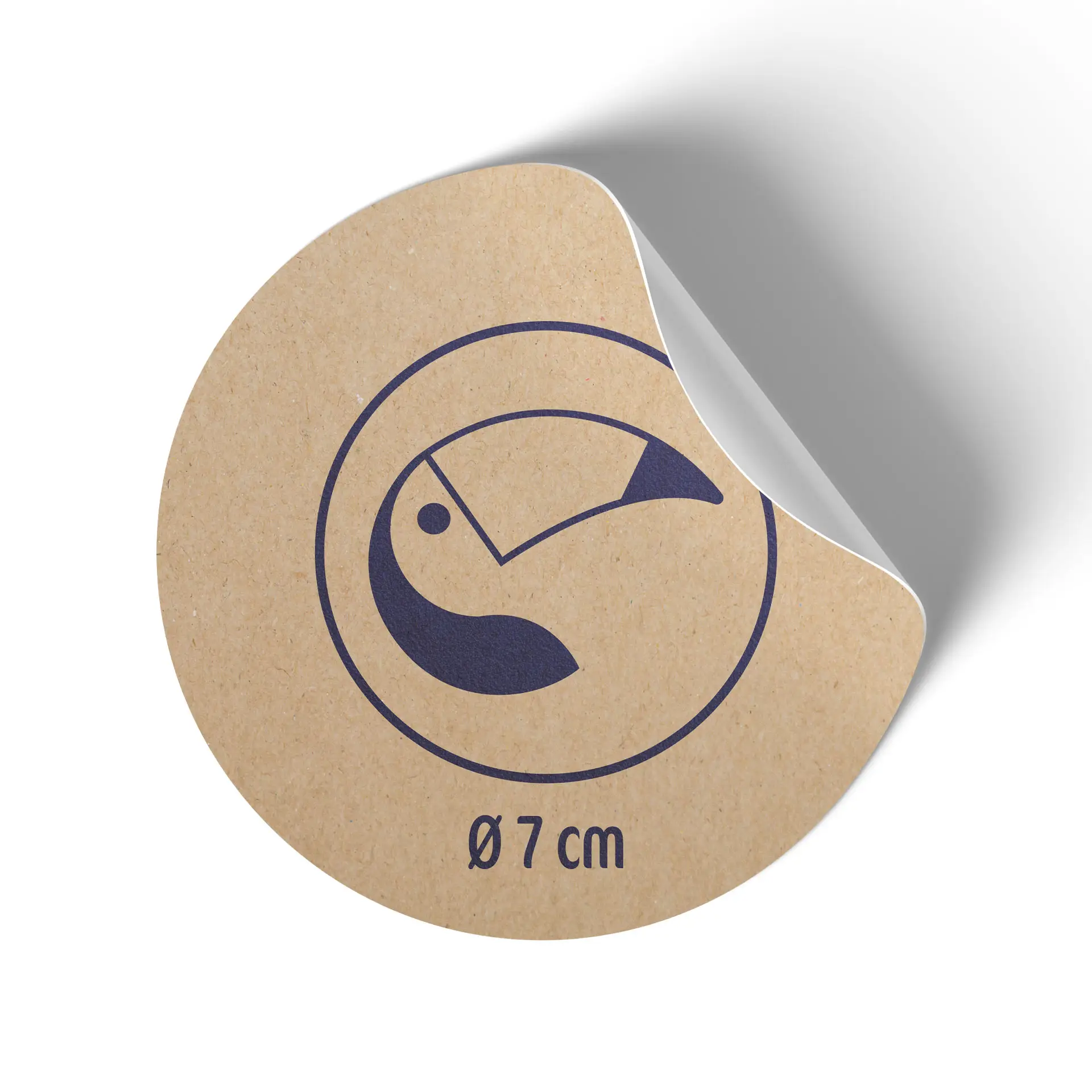 Circular kraft paper coaster with a toucan illustration; diameter of 7 cm; edge slightly curled.