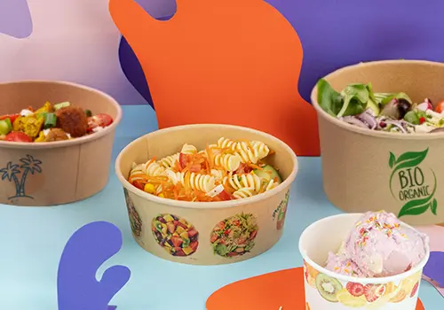 Brown biodegradable salad bowls with assorted salads; one bowl is open with a lid nearby.