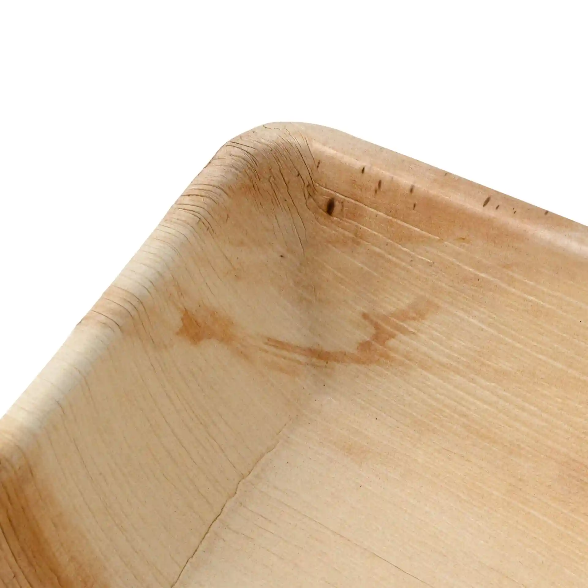 Close-up of a square palm leaf bowl with visible grain texture and rounded edges.