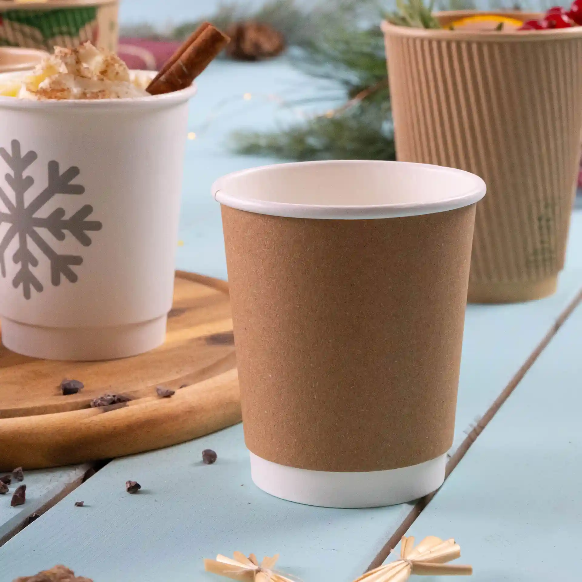 Brown double-walled cardboard coffee cup with a white inner lining, 8 oz capacity, on a light blue surface.