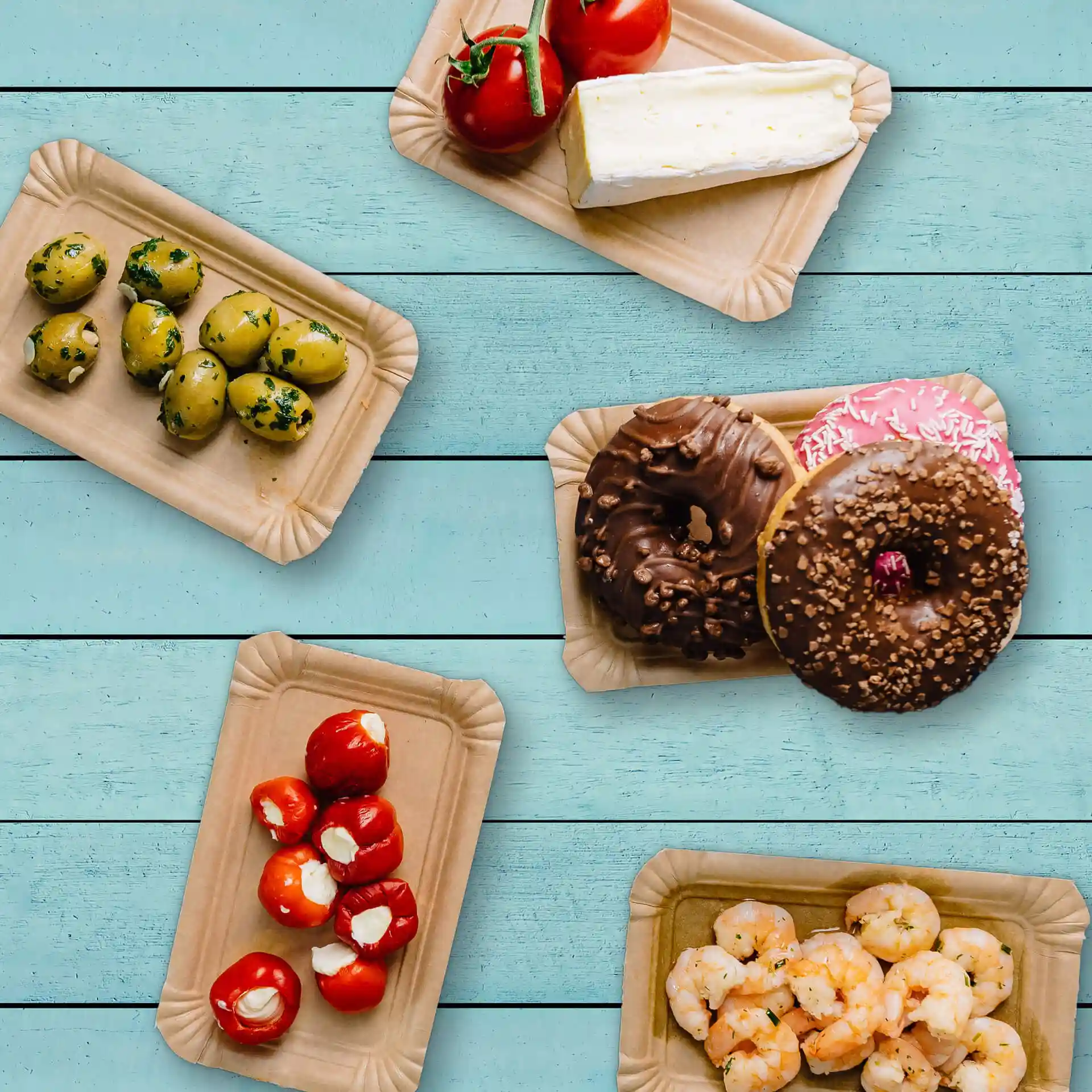 Image of several rectangular brown cardboard plates with various food items: olives, tomatoes, cheese, donuts, and shrimp.