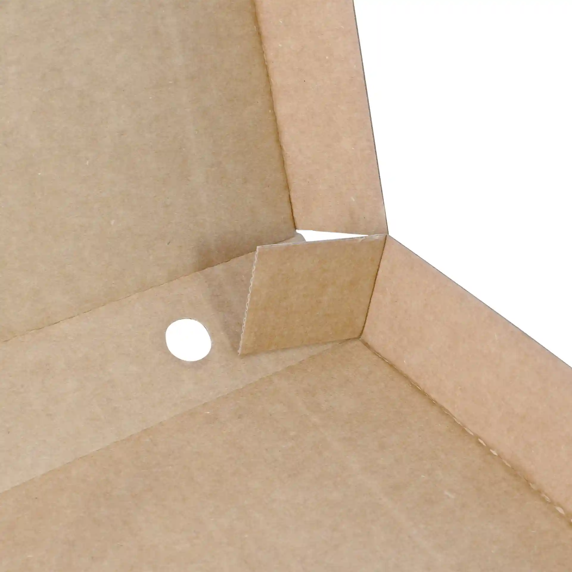 Close-up of a brown cardboard pizza box corner with a cut-out tab and a circular hole.