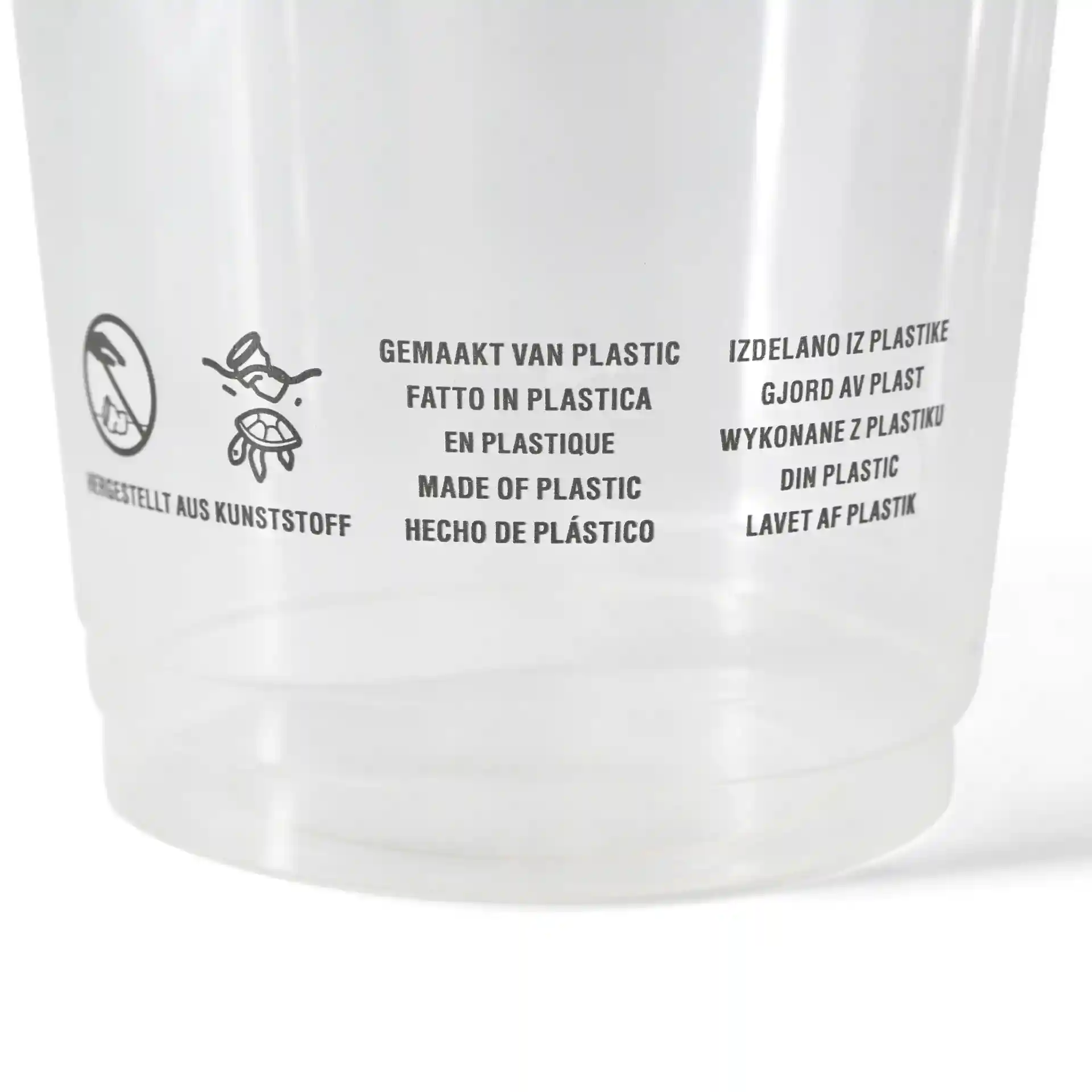 Clear plastic cup with printed multilingual text about material and symbols on the side.