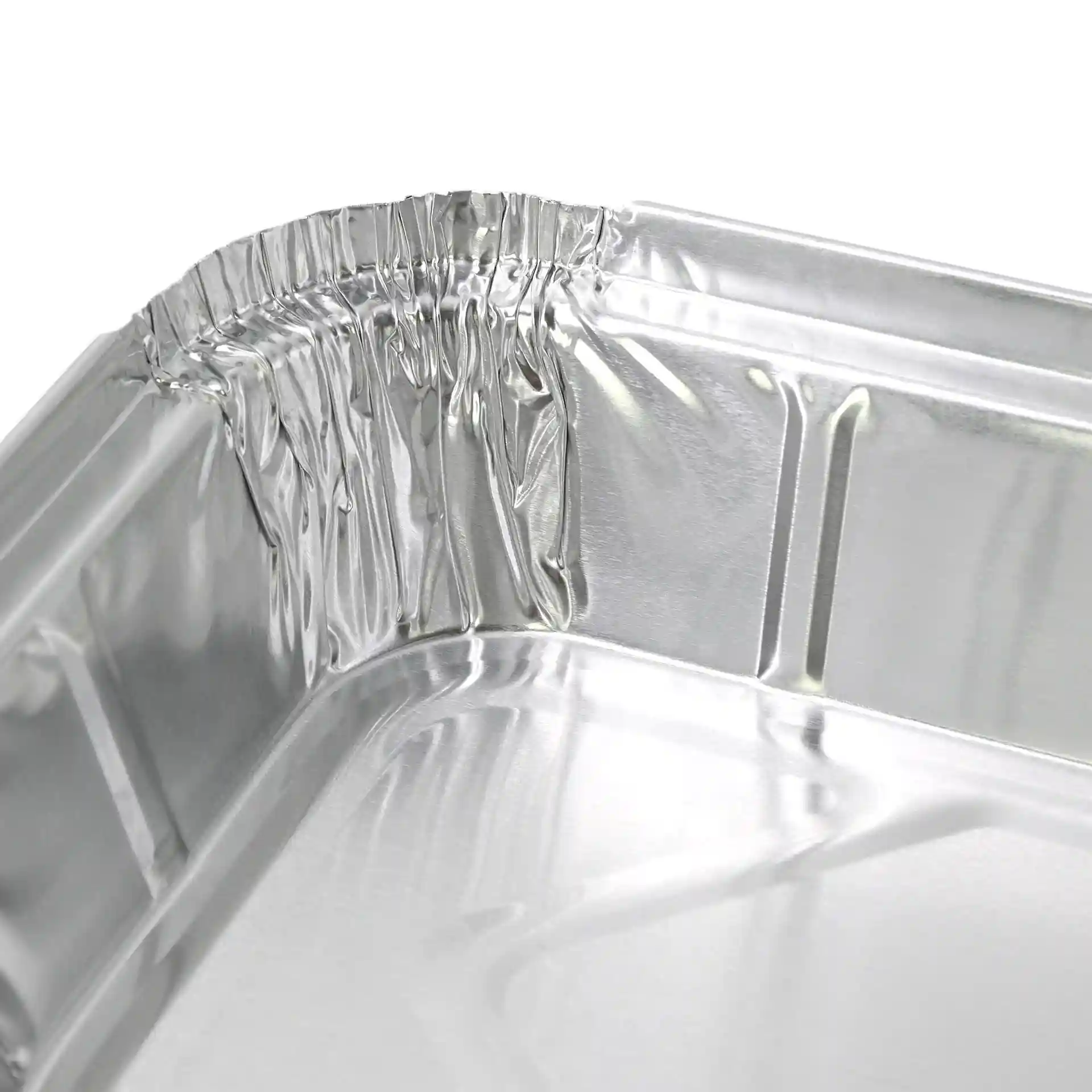 Close-up of the corner of a rectangular aluminum container, showing crimped edges and a shiny surface.