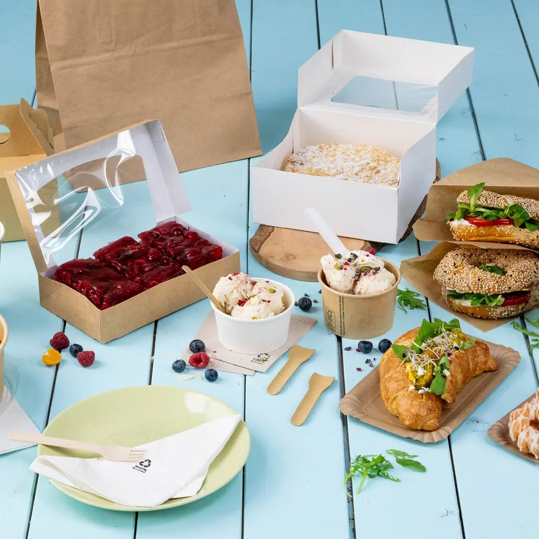 Assorted food items including sandwiches, desserts, and ice cream in various containers on a blue wooden surface.