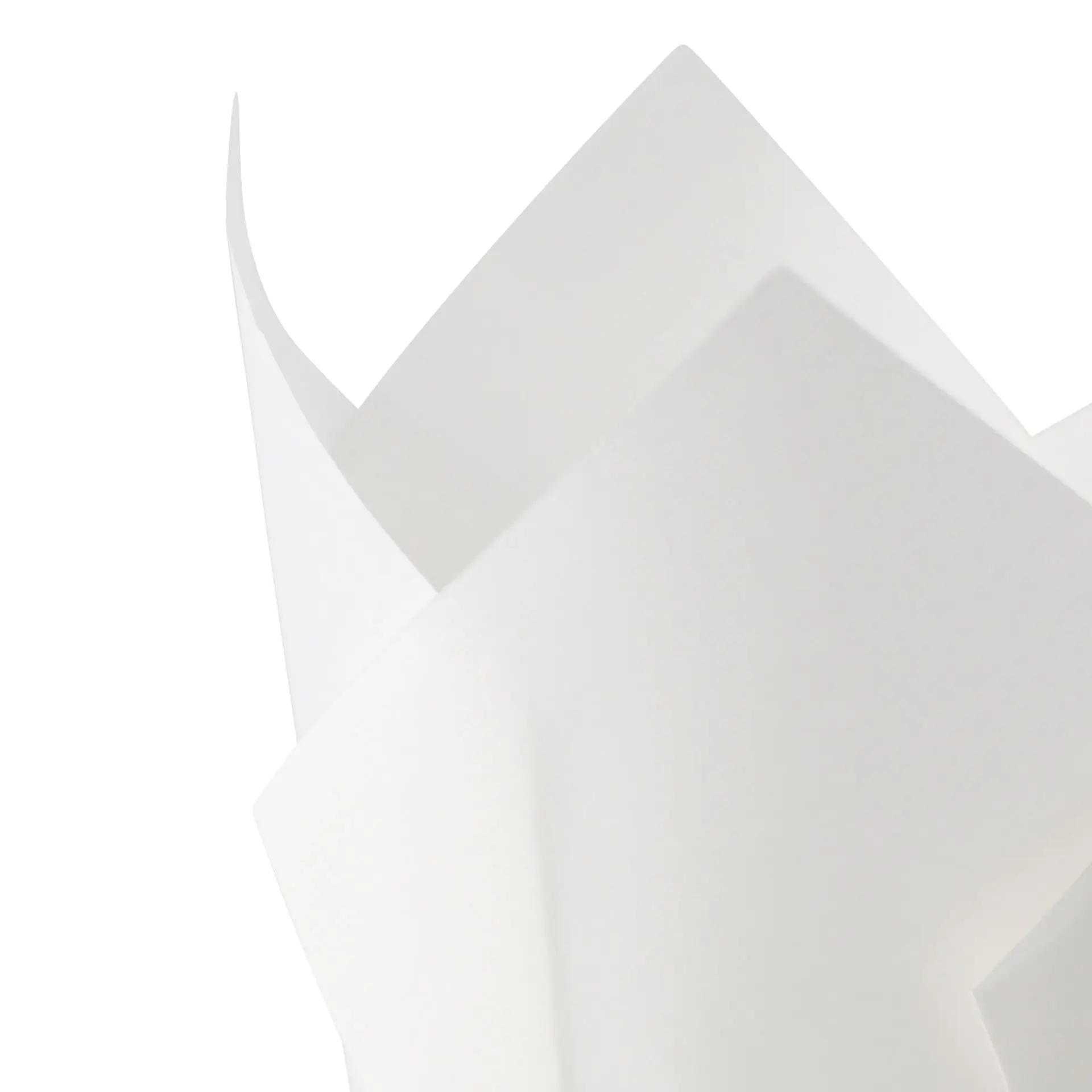 One white greaseproof paper muffin cup with pointed edges; multiple similar cups are partially visible behind it.