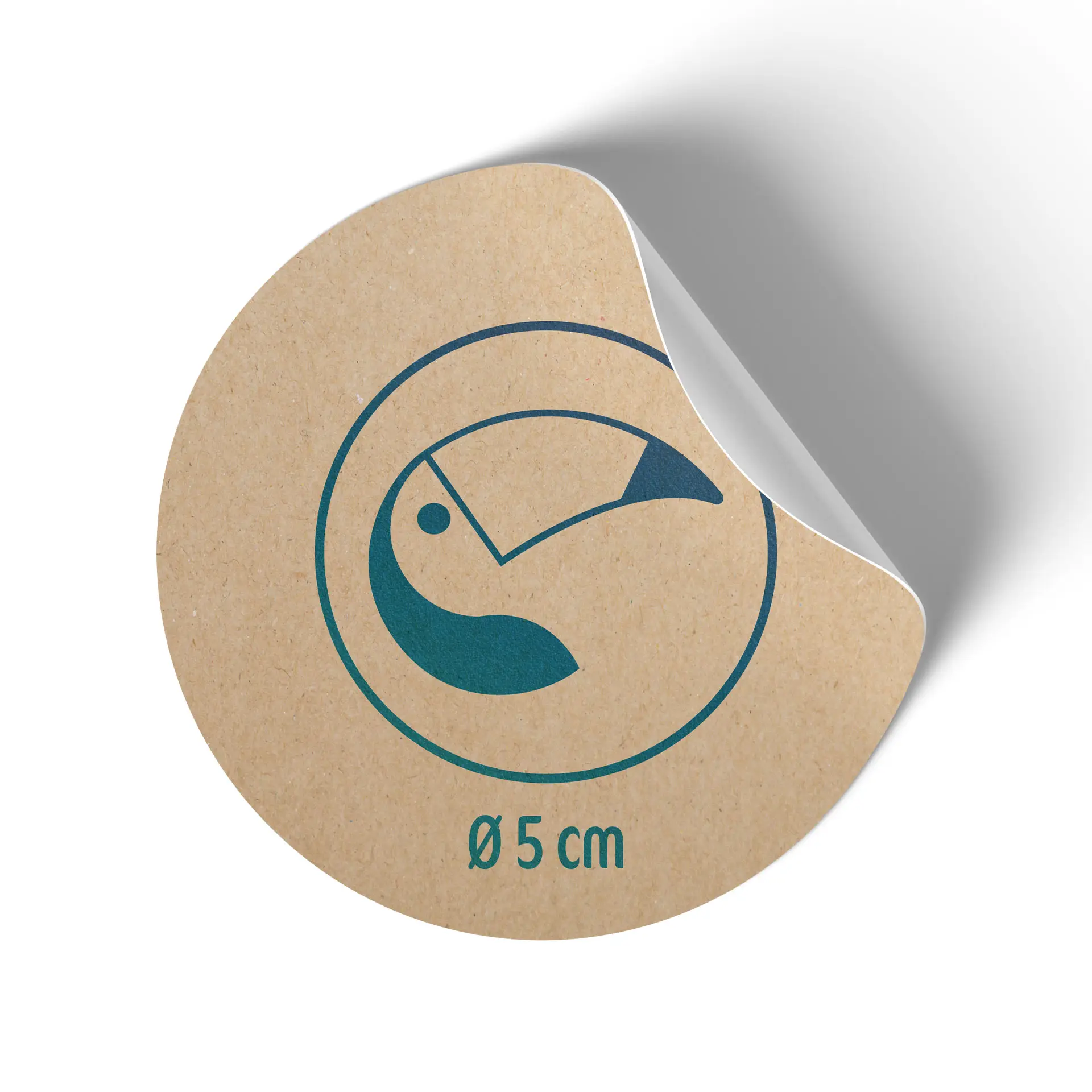 Round kraft paper label, 5 cm in diameter, featuring a blue toucan design and a backing slightly peeled away.