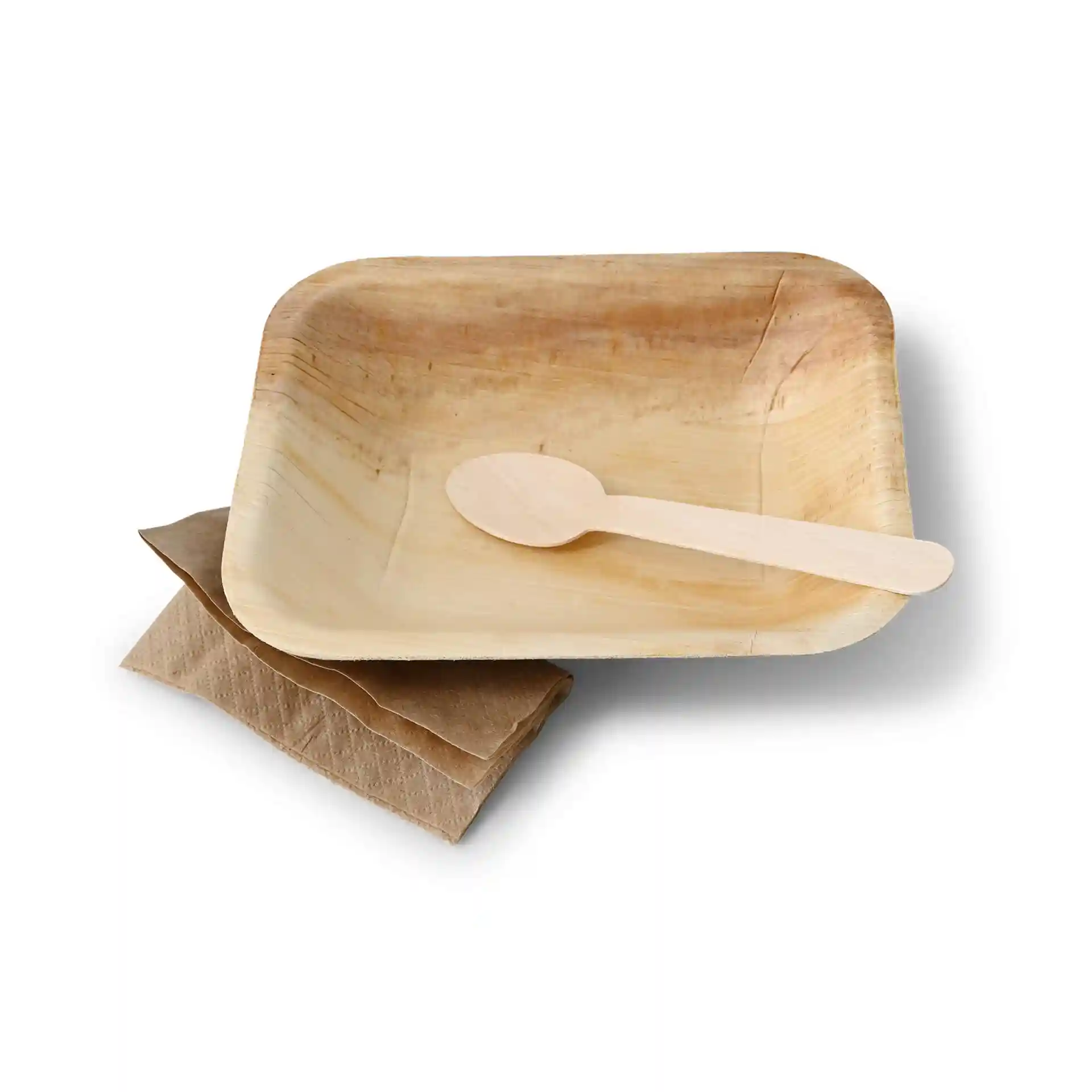 Rectangular palm leaf plate with a wooden spoon and two brown napkins stacked underneath.