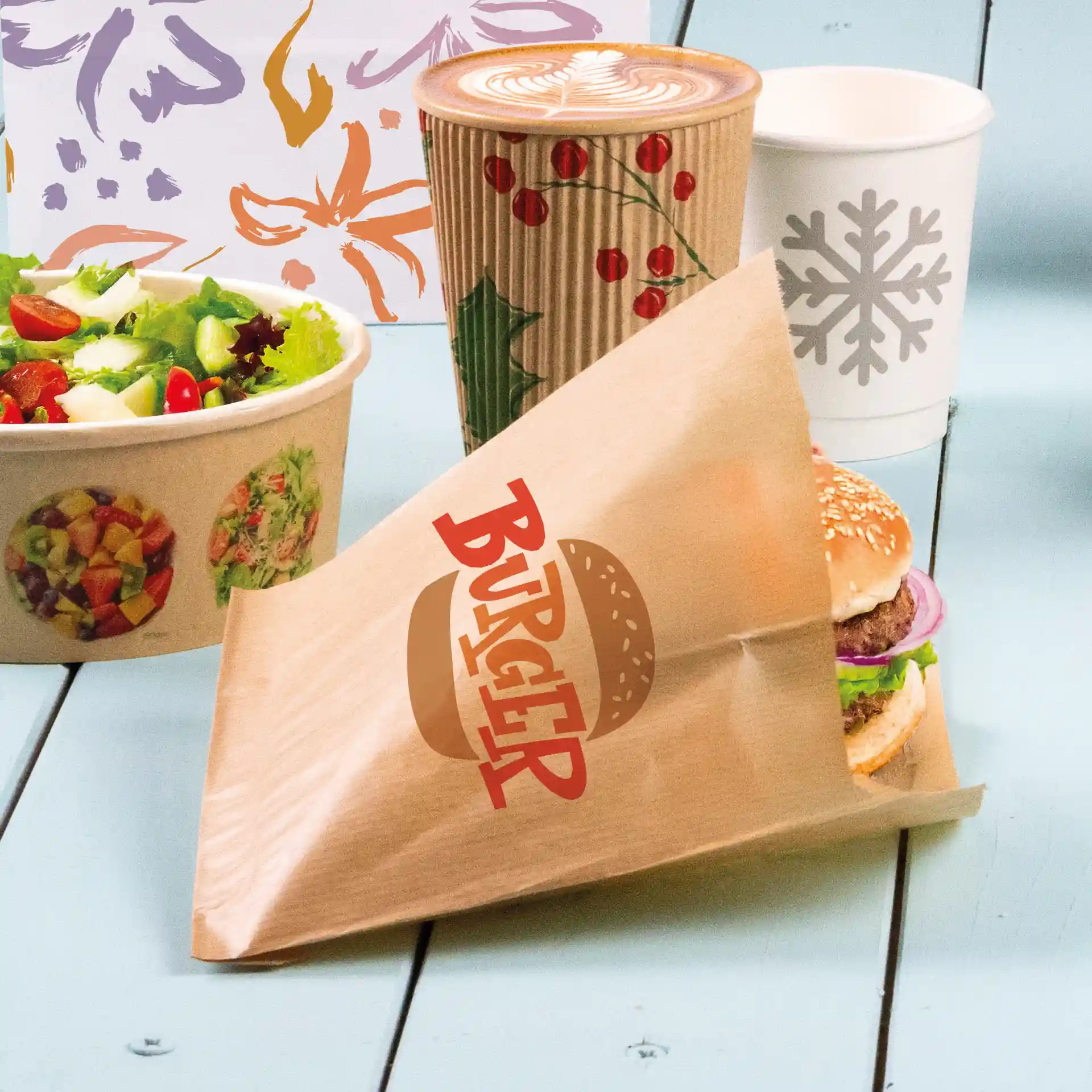 Brown printed burger sleeve with a visible burger, salad bowl, and coffee cup in the background.