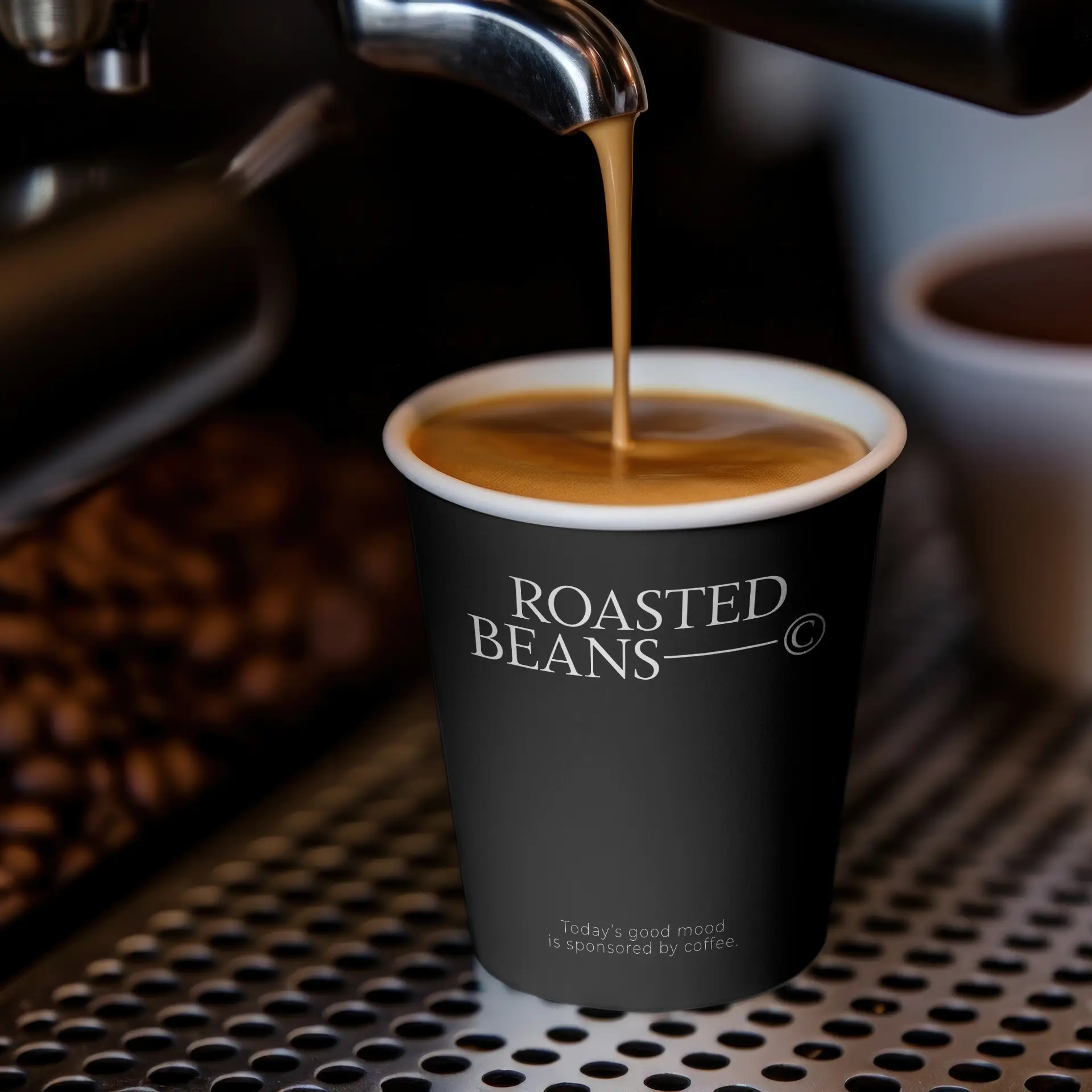 Black paper cup with "ROASTED BEANS" logo, filled with coffee, placed on a coffee machine's drip tray.