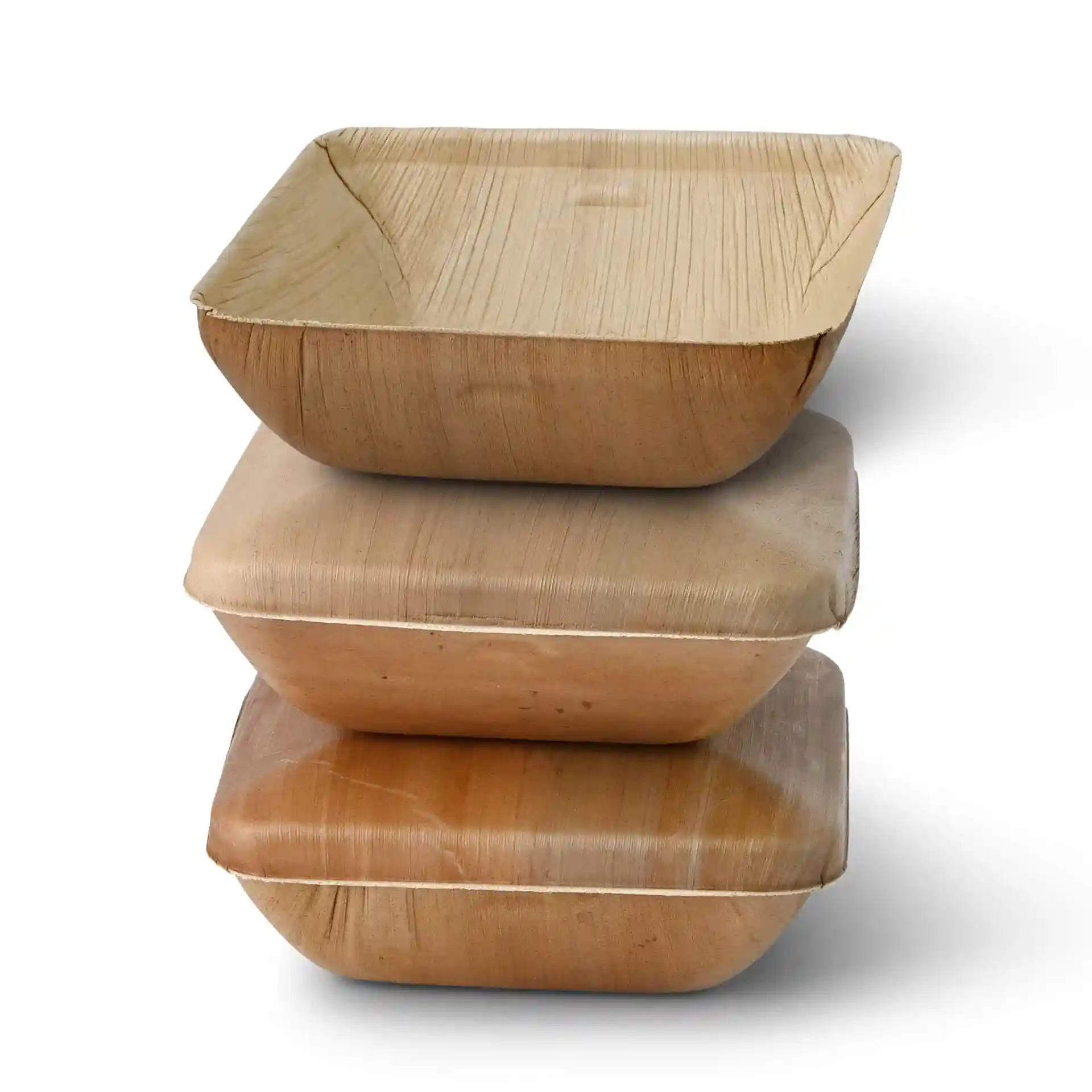 Stack of three square palm leaf bowls, showing natural grain texture, with the top bowl slightly tilted.