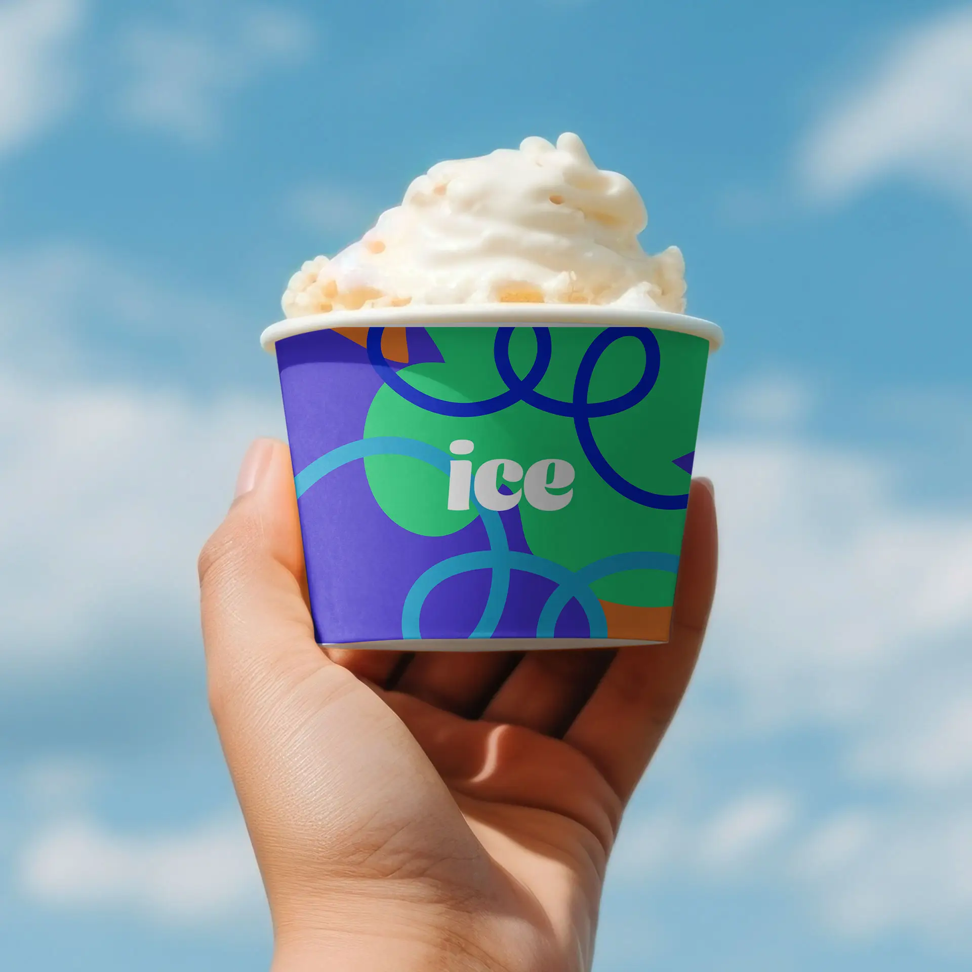 Custom printed ice cream cup held in hand, featuring a colorful design with "ice" text, set against a blue sky.