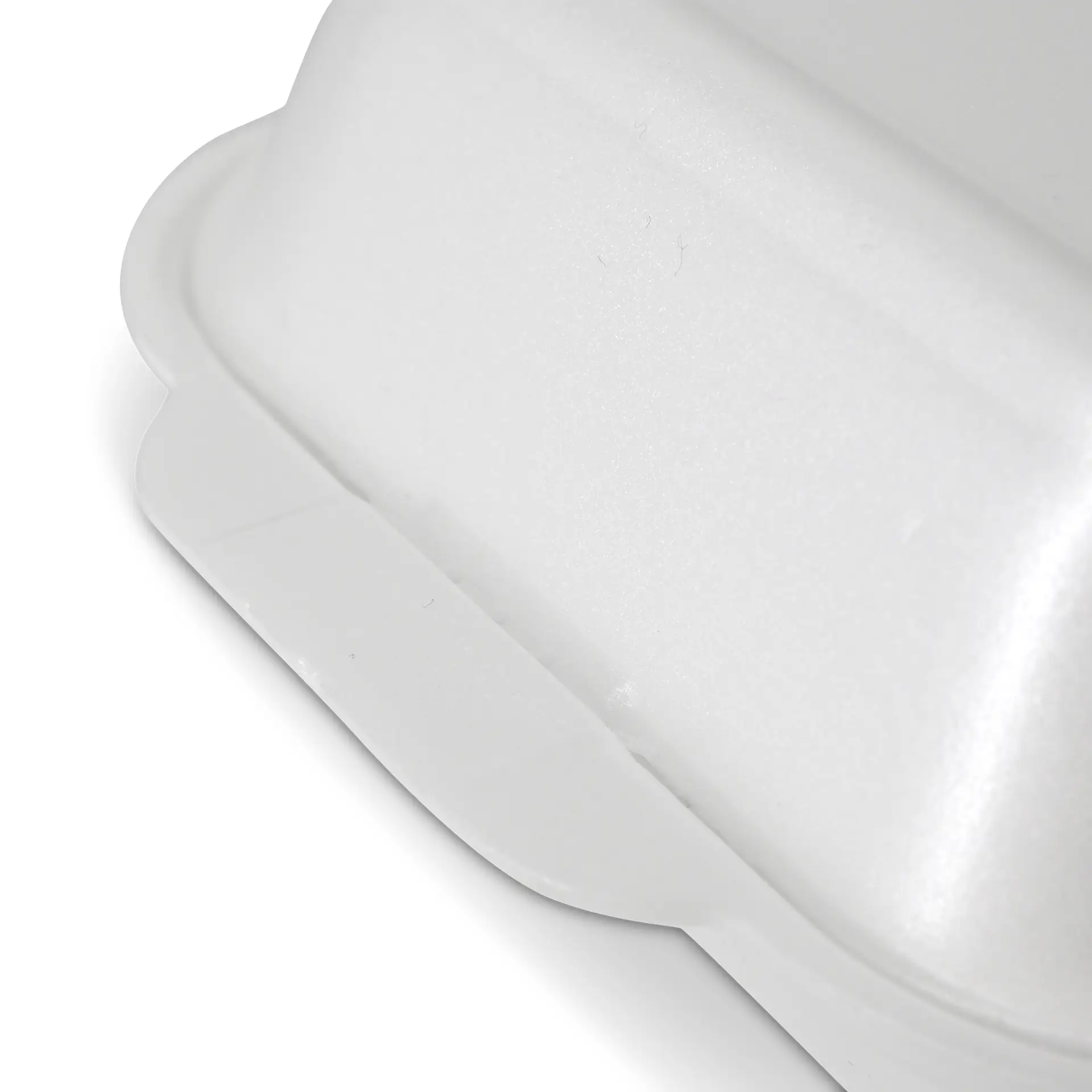 White foam takeout container with a lid, showing a close-up of the edge and surface texture.