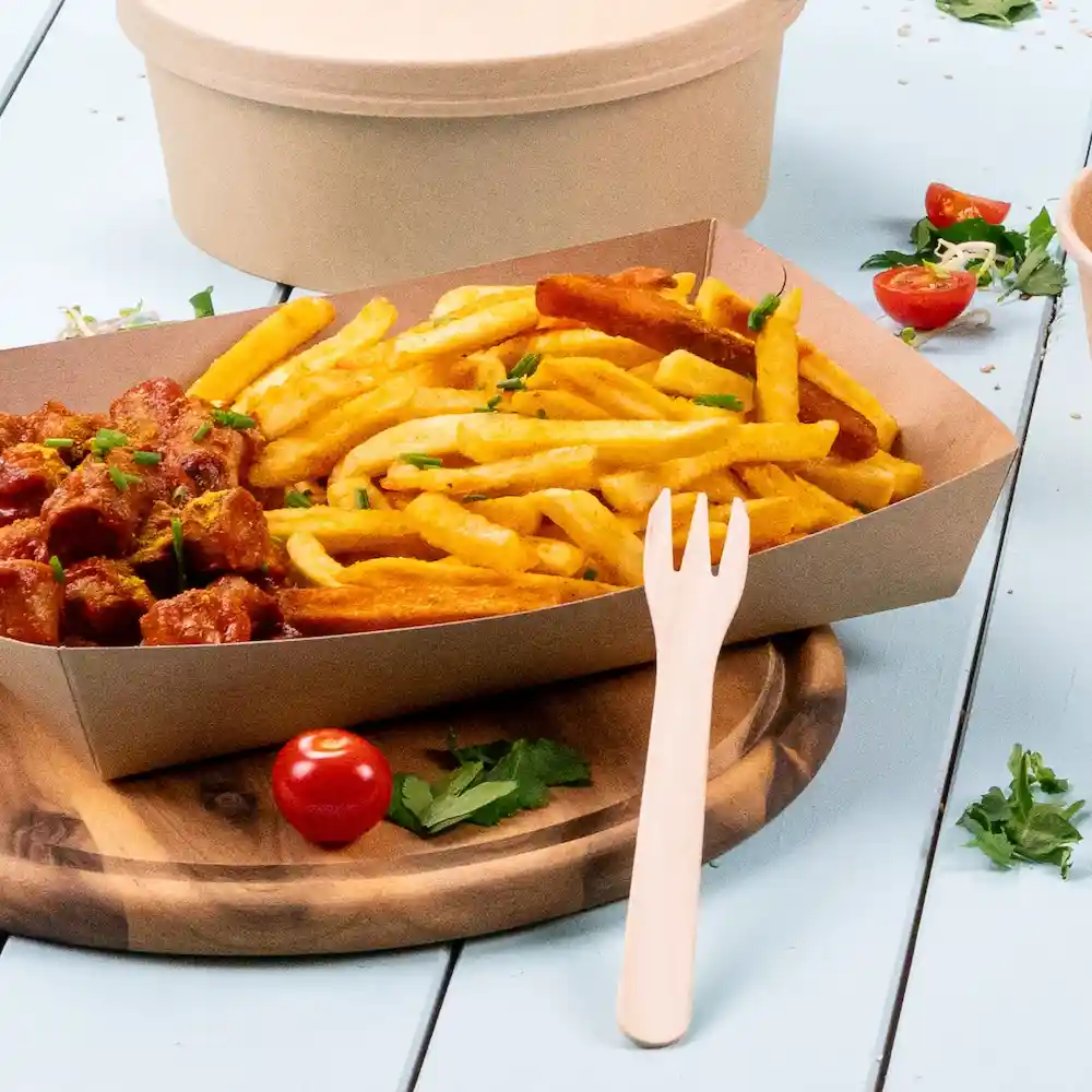 Serving of fries with a side of sausage in sauce, garnished with herbs, and accompanied by a wooden fork on a wooden board.