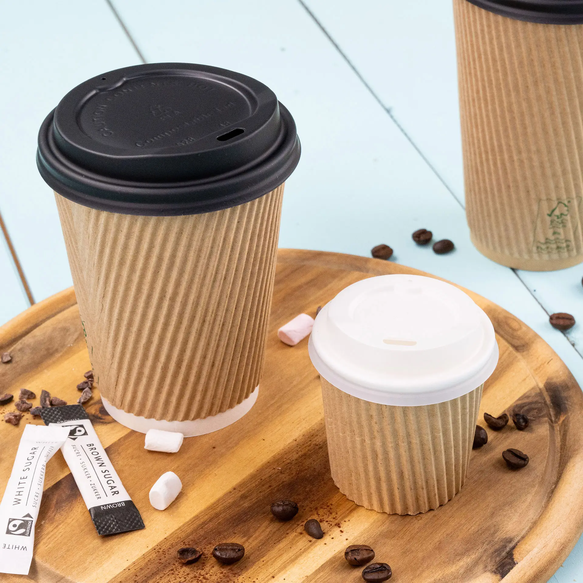 Image of a 4 oz ribbed coffee cup with a white lid, placed on a wooden surface with coffee beans and sugar packets.