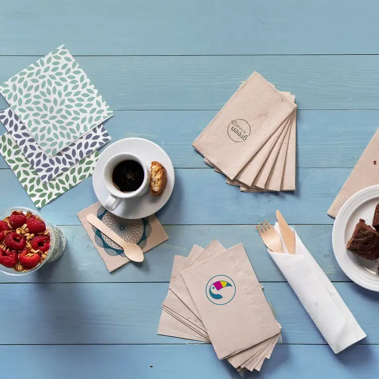 Tabletop arrangement featuring patterned napkins, coffee cup with biscuit, dessert, and fresh raspberries in a glass.