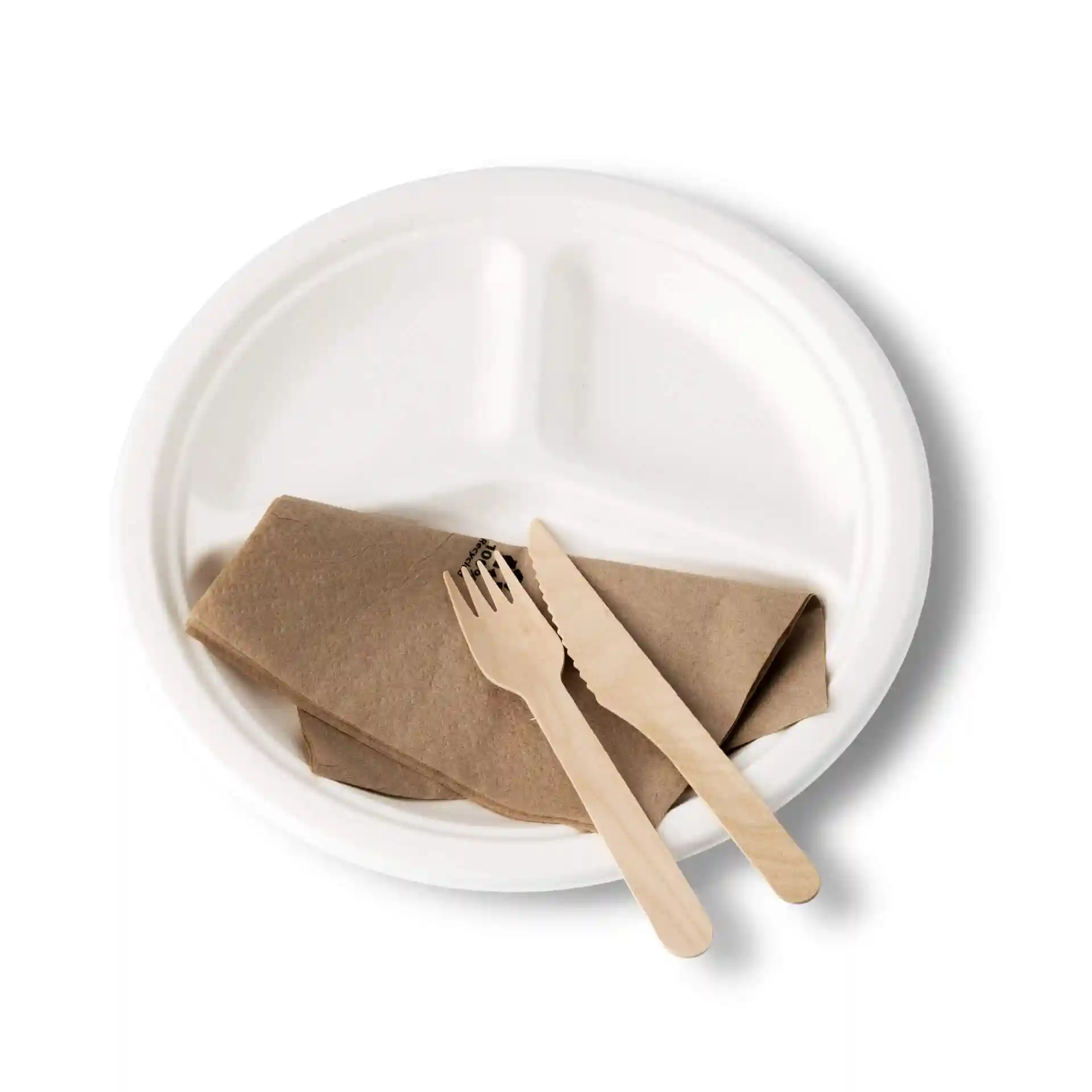 Round white sugarcane plate with three compartments, a brown napkin, and wooden fork and knife.