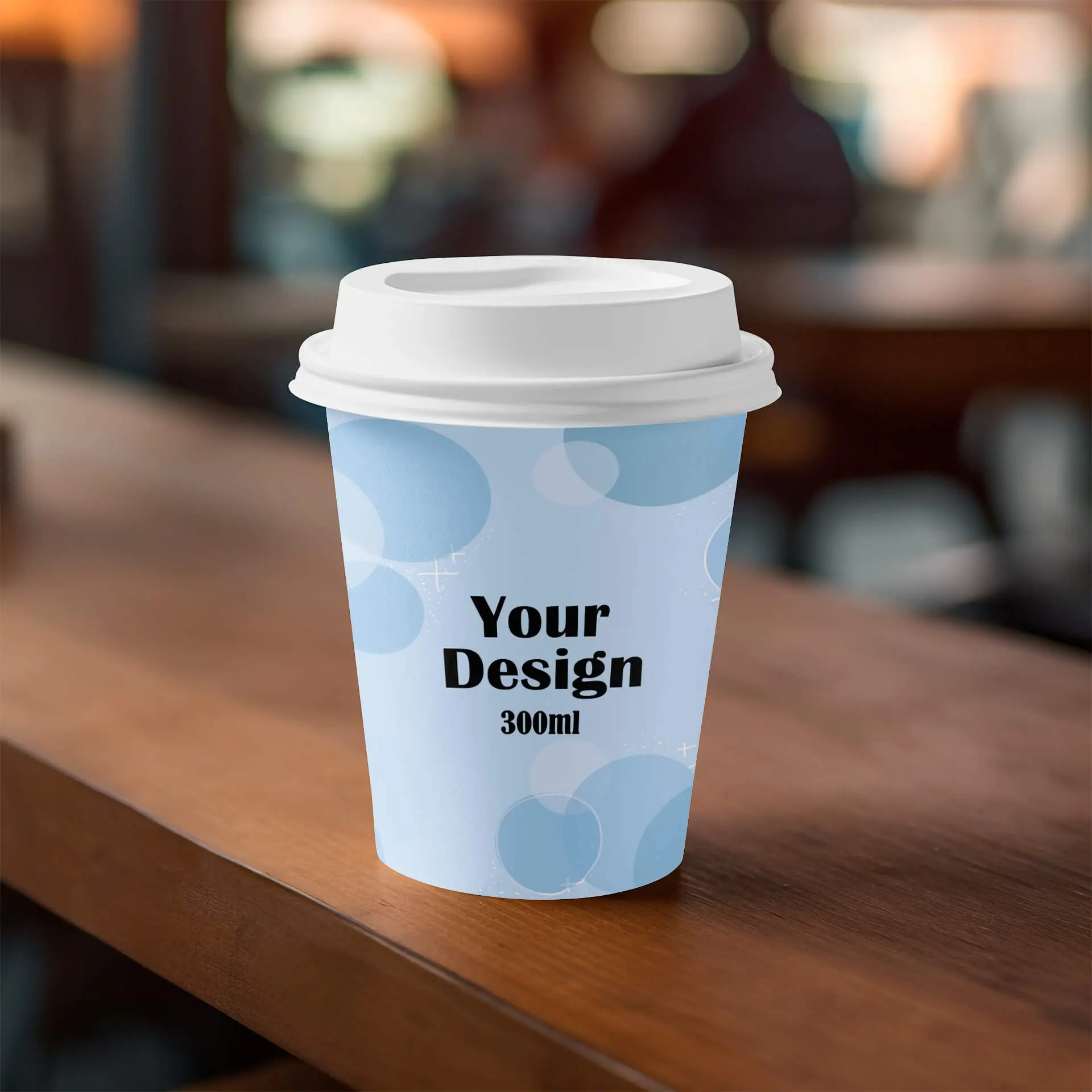Single-wall paper cup with custom design, 300 ml capacity, blue background with pattern, placed on a wooden surface.