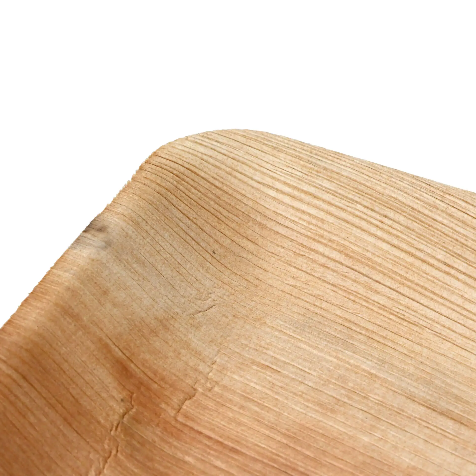 Close-up of a flat palm leaf plate with a natural wood grain texture, showing the curved edge and smooth surface.