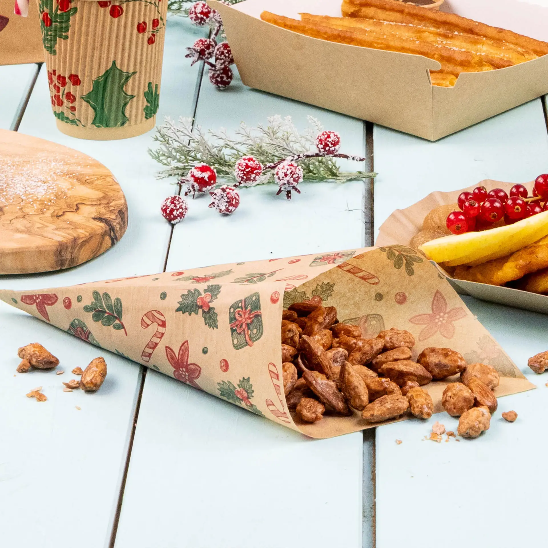 Brown greaseproof bag with winter design, containing nuts, placed on a light blue surface with food items and decorations.