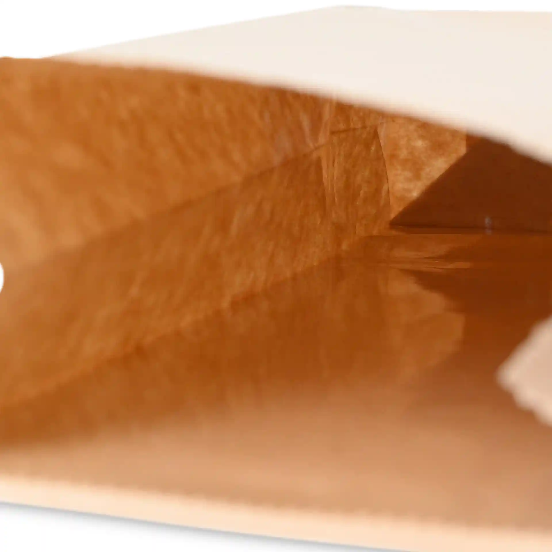 Interior view of a brown kraft paper block bottom bag with a tin tie, showing the bag's depth and texture.