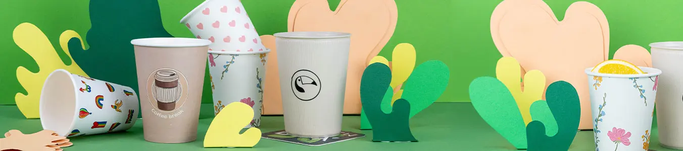 Image of various customizable printed cups with colorful paper cutouts on a green background.