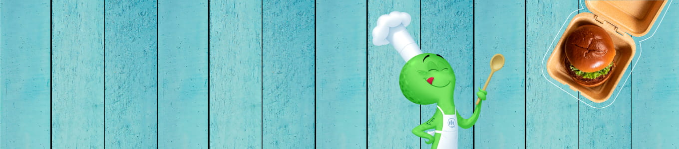Green cartoon chef character with a spoon, next to a burger in a brown takeout box on a blue wooden background.