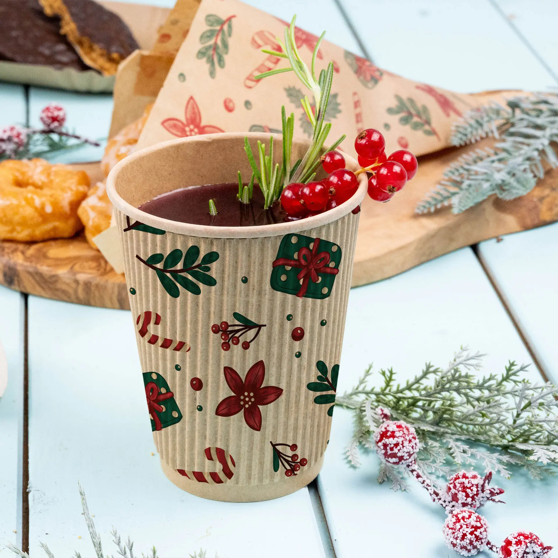 Brown ripple cup with winter design, filled with a drink and garnished with red berries and rosemary, on a light blue surface.