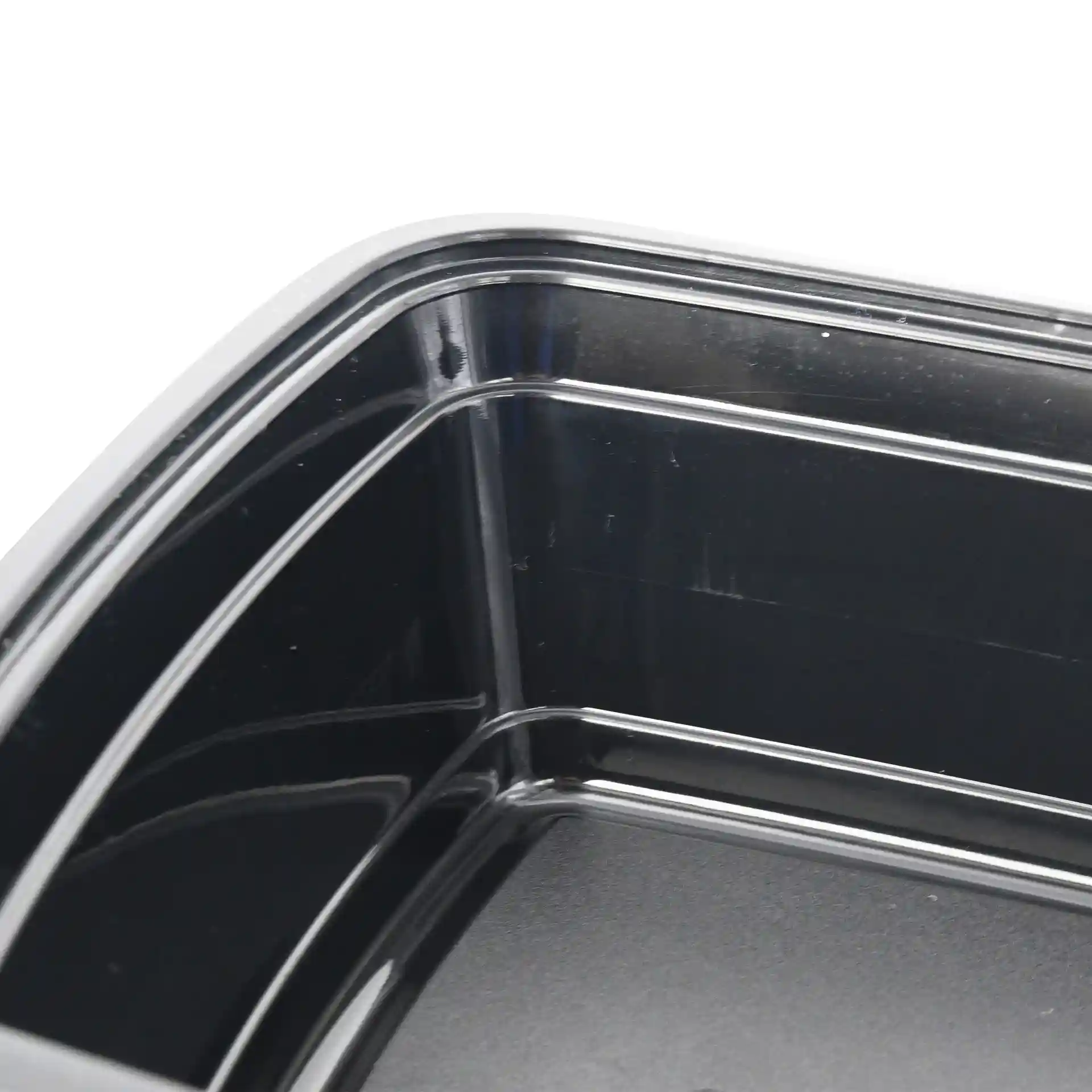 Close-up view of a black rectangular reusable container with visible interior corners and edges.