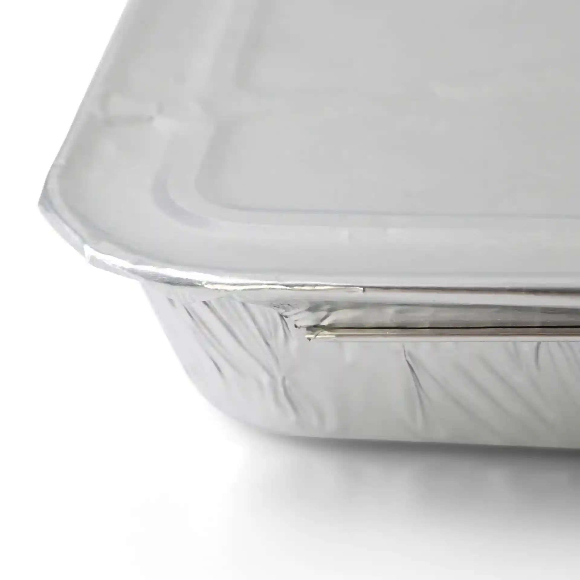 Aluminium lid for a rectangular two-compartment meal tray, showing the edge and surface details.