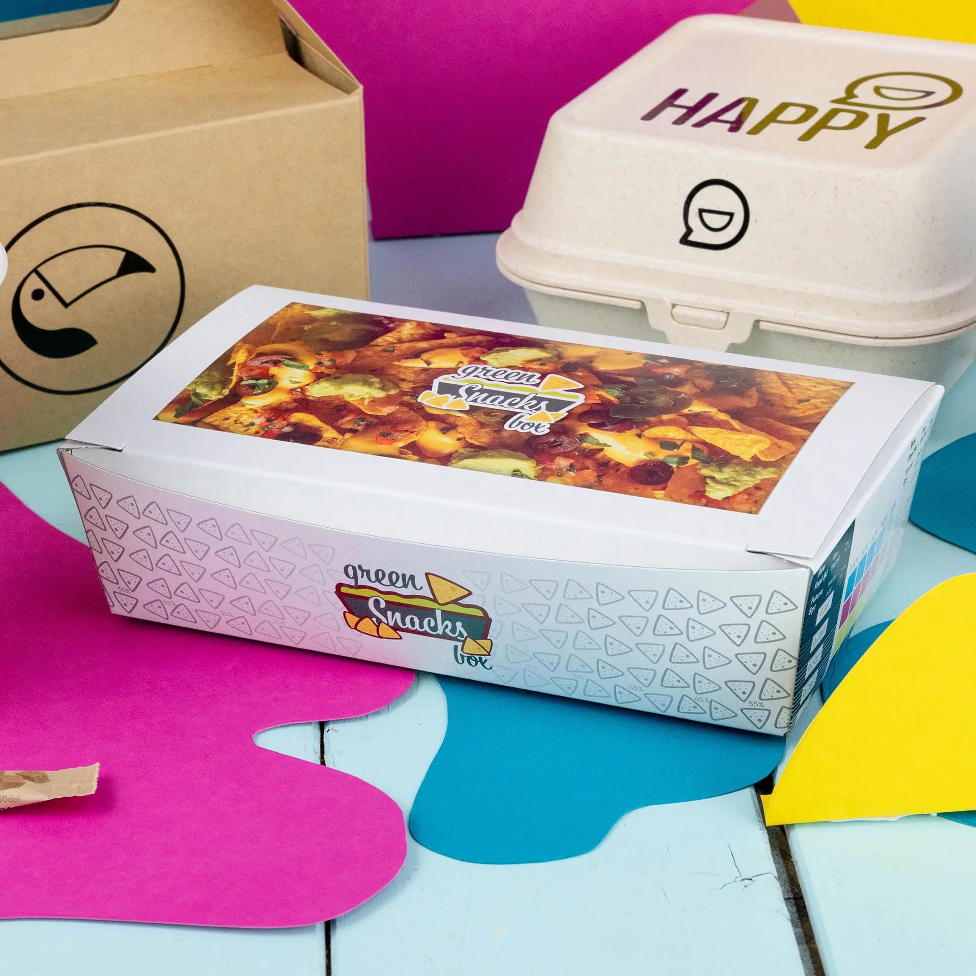 Snack box with a printed design, 750 ml capacity, placed on a colorful background with other containers nearby.