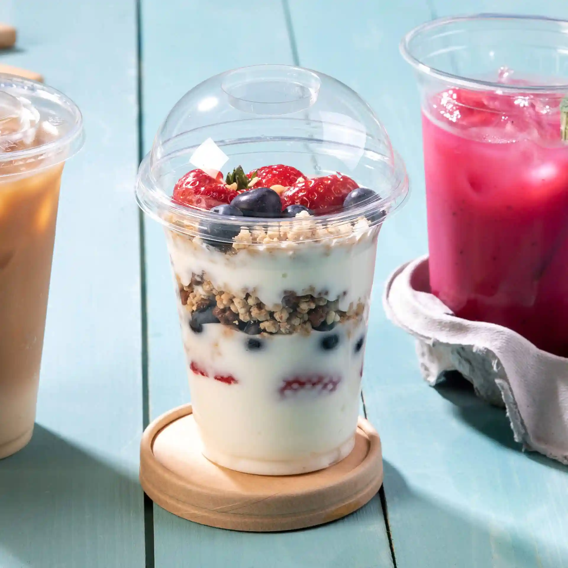 Transparent PLA dome lid with a diameter of 96mm, shown on a wooden coaster, with yogurt and berries inside.