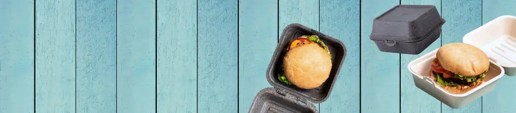 Green cartoon chef character with a spoon, next to a burger in a brown takeout box on a blue wooden background.