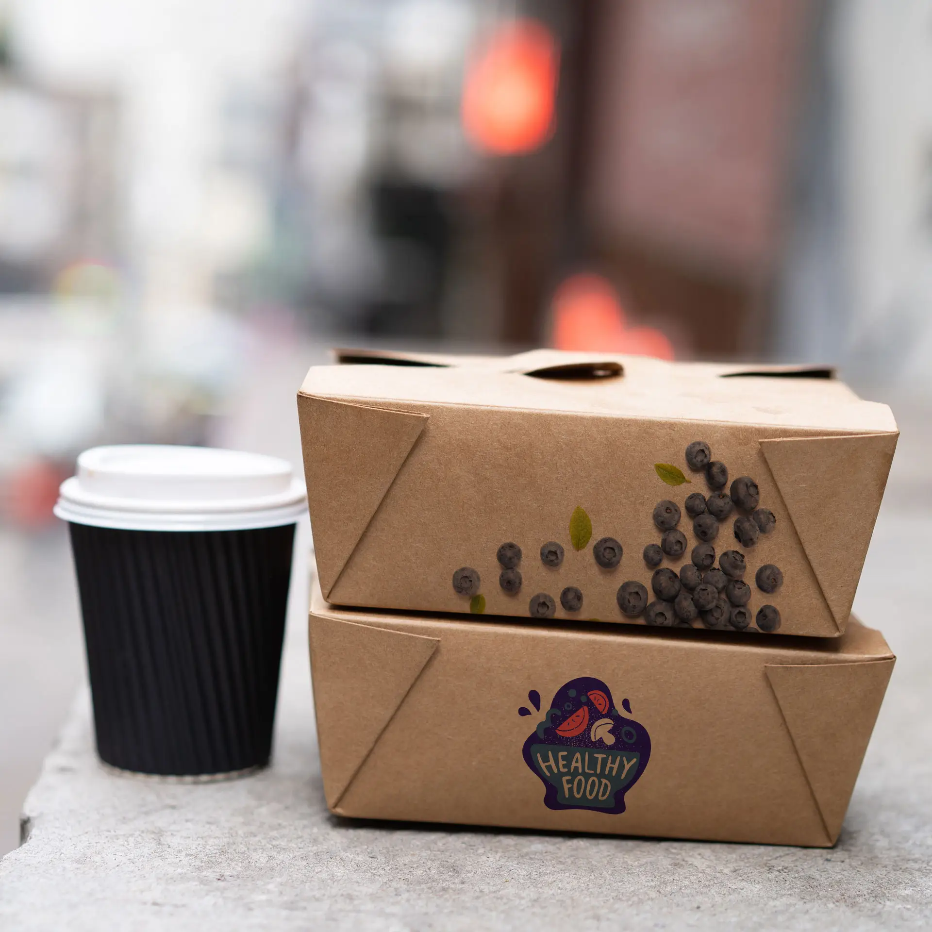 One printed brown takeaway box featuring a "Healthy Food" label and graphic, positioned above another similar box; a black cup is next to them.