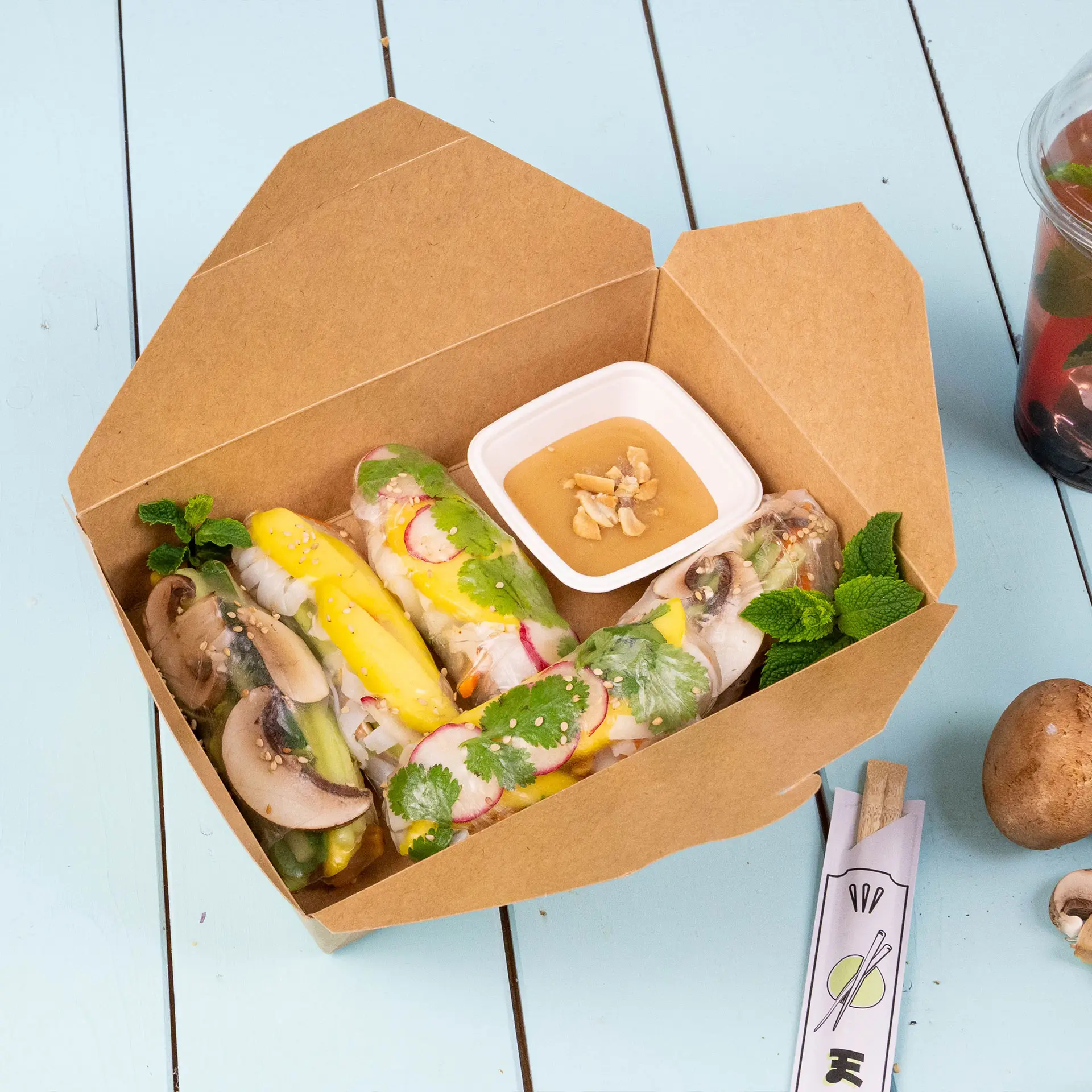Brown takeaway food containers, 1100 ml capacity, with chopsticks and food items; biodegradable packaging on a light blue surface.