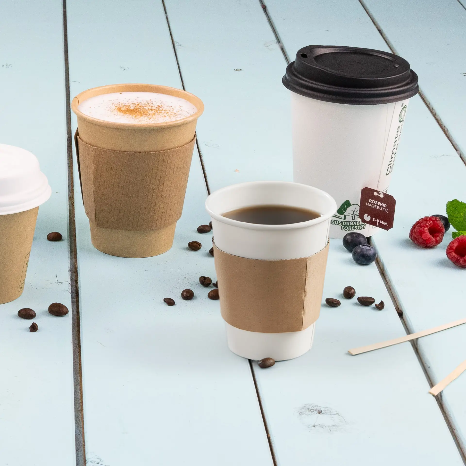 Brown cardboard cup sleeve for 150/200/250 ml paper cups, placed on a blue wooden surface with coffee cups.