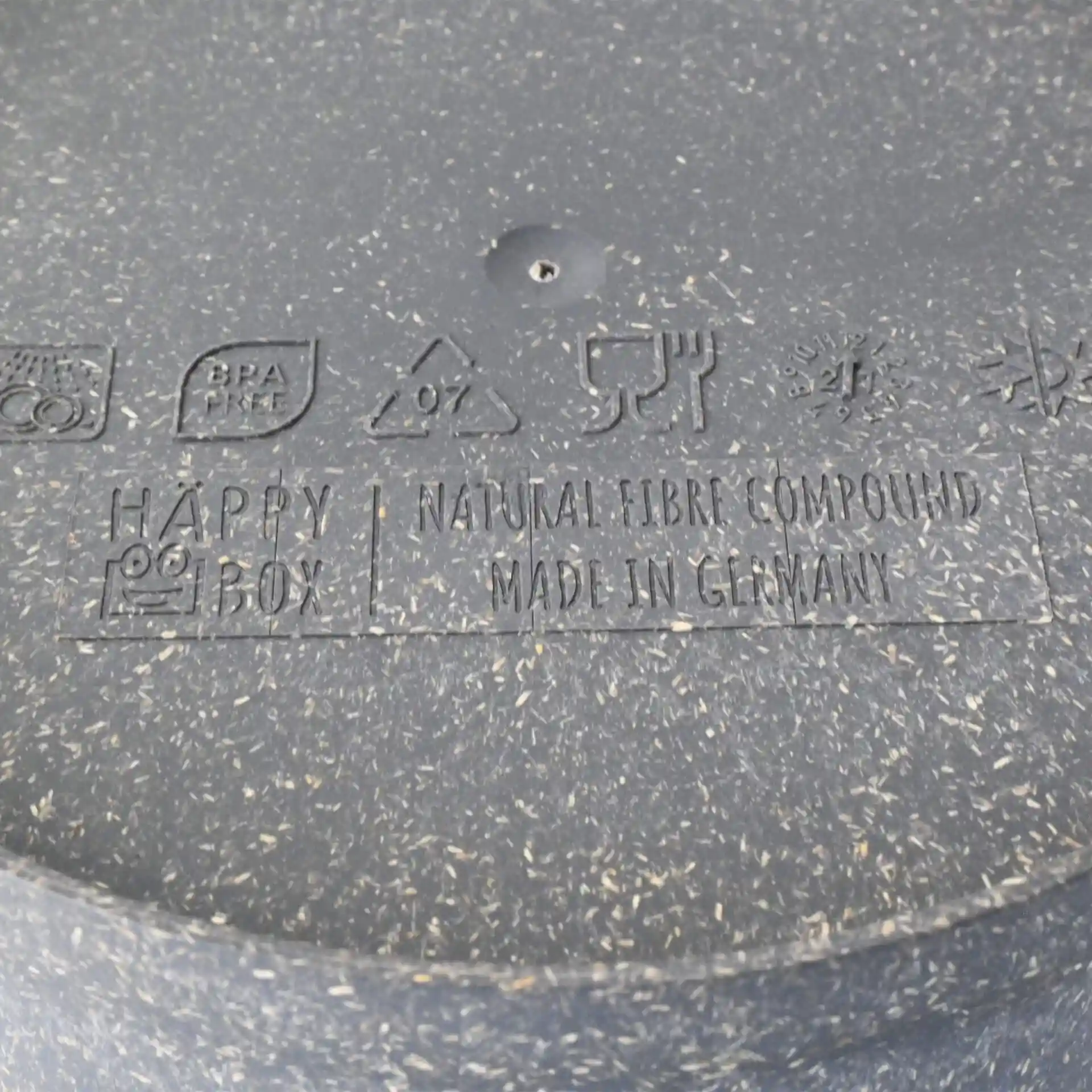 Label with symbols and text on a grey reusable bowl made of natural fibre compound, indicating various features and information.