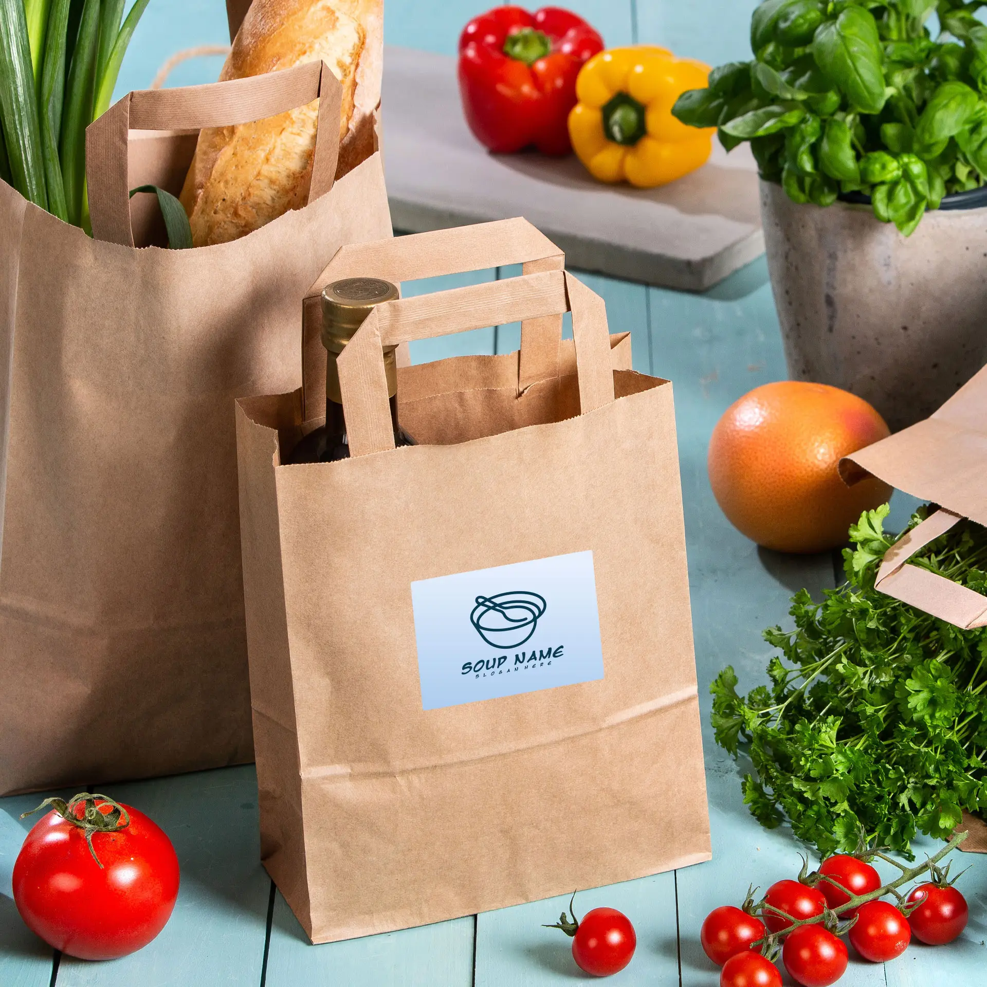 Brown paper bags with handles displaying a customizable printed label, surrounded by fresh vegetables and herbs.