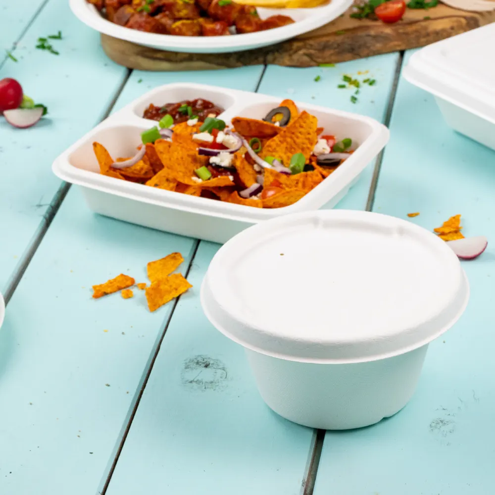 White disposable dip cups on a light blue wooden surface; tortilla chips in a white compartmentalized container nearby.