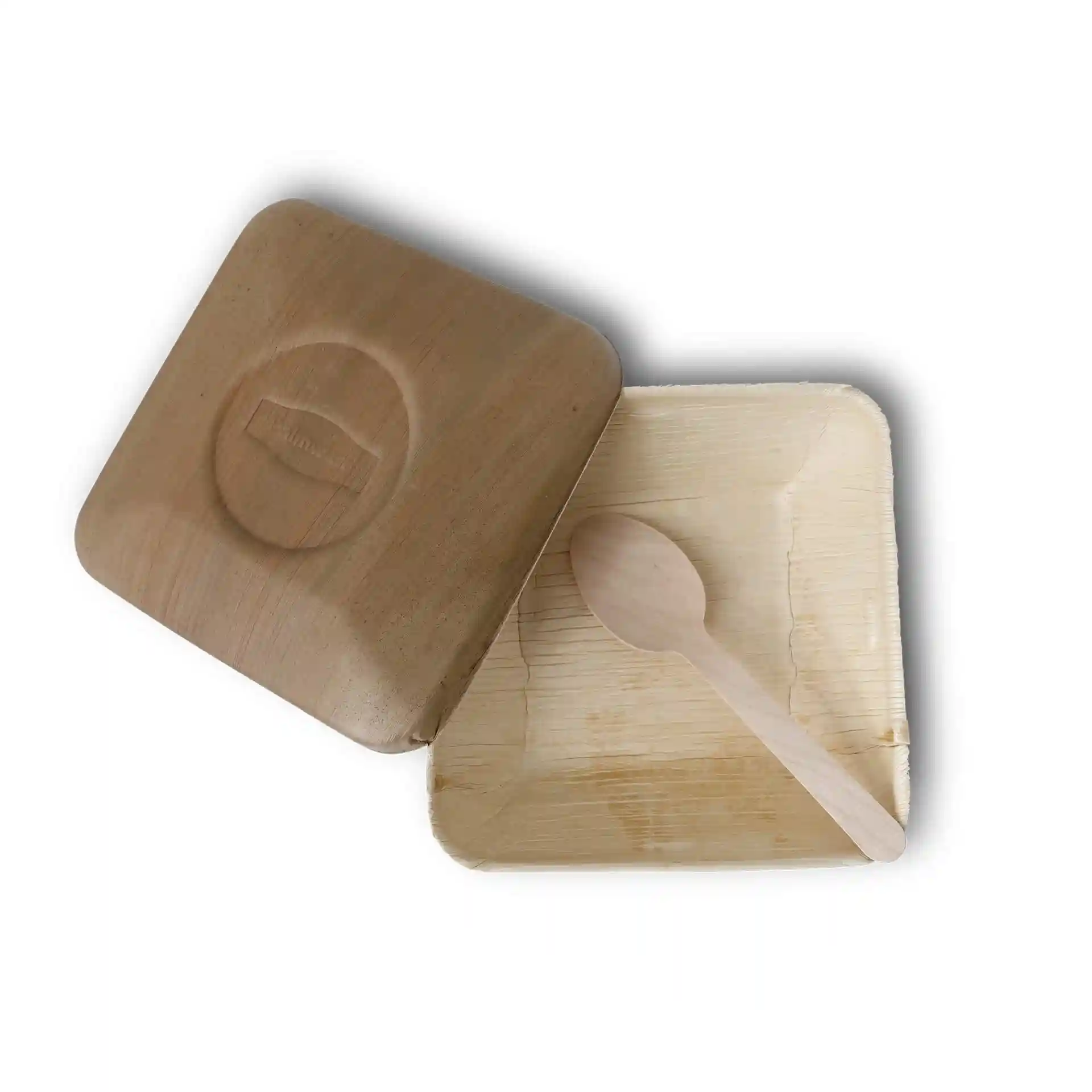 Square palm leaf bowl with a lid and a wooden spoon inside, shown from above.