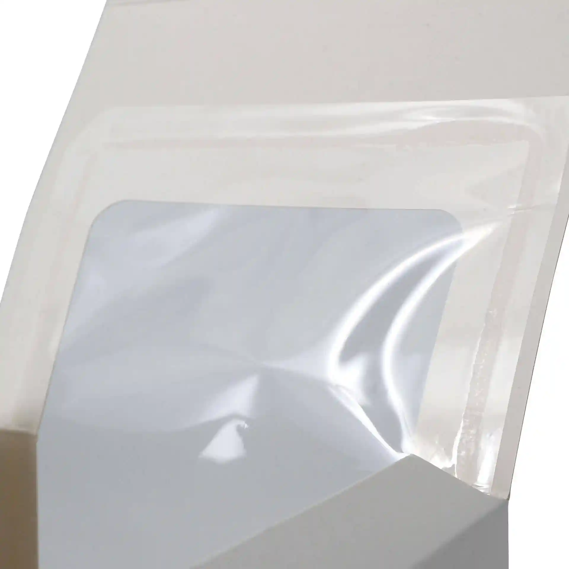 Close-up of a white pastry box with a clear cellulose window, showing the box's opening and inner surface.