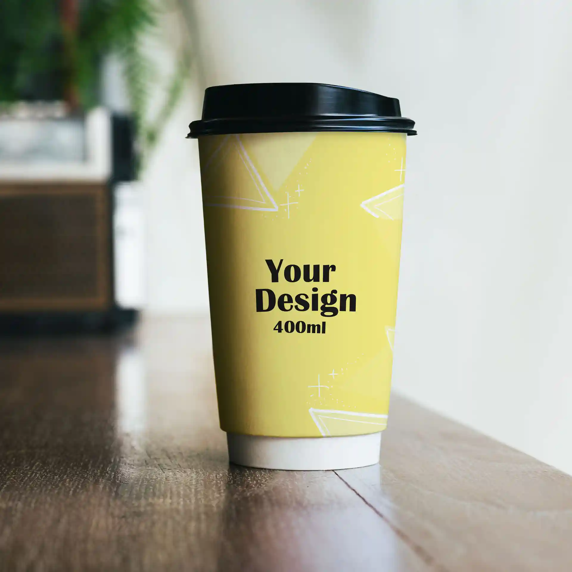 Yellow paper cup with a black lid, featuring a design and text indicating a volume of 400 ml.