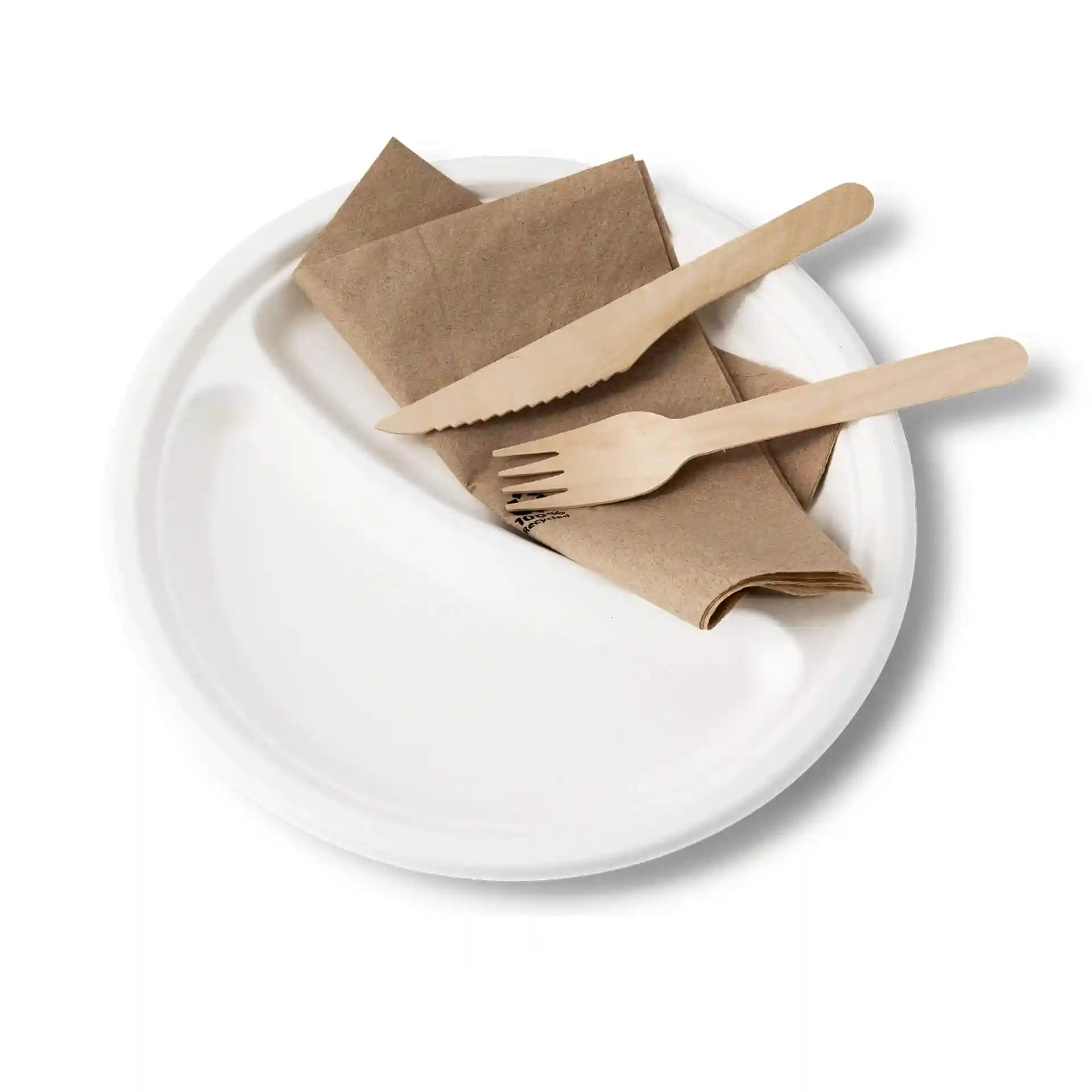 Round white sugarcane plate with two compartments, accompanied by a brown napkin and wooden knife and fork.