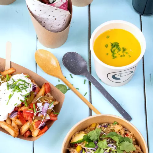 Image features various food items including fries with toppings, a rice bowl with herbs, a soup in a cup, and reusable cutlery on a blue surface.
